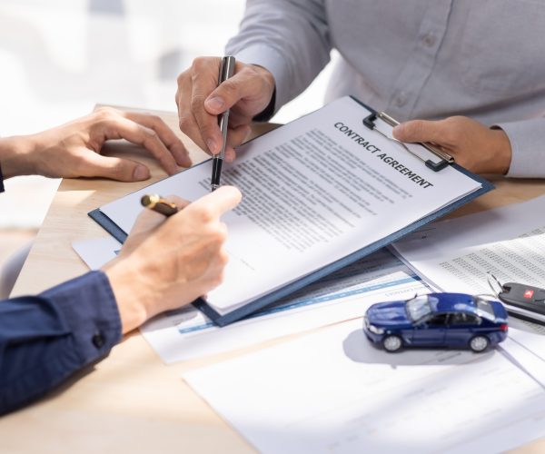 Car Insurance document or lease concept the car broker assisting his customer and explaining the Car Insurance document or lease concept the car broker assisting his customer and explaining the