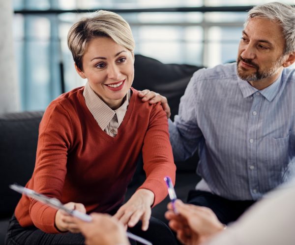 Mid adult couple making an agreement with their insurance agent on a meeting in the office. Mid adult couple making an agreement with their insurance agent on a meeting in the office.